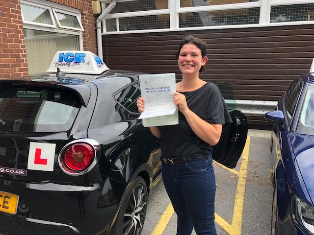 girl next to house with driving test certificate