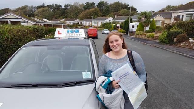 girl stood on road with driving certificate